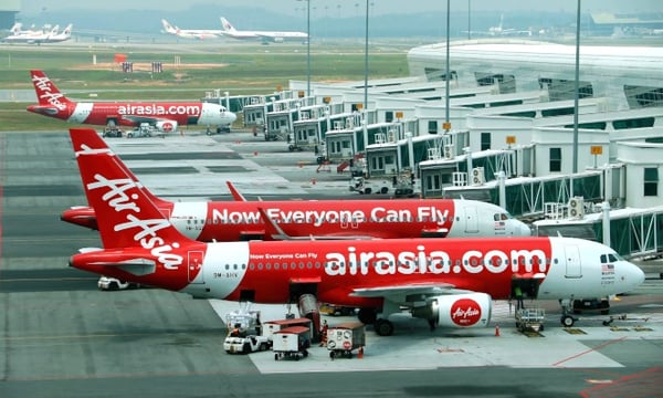 AirAsia planes at an airport, ready for boarding.