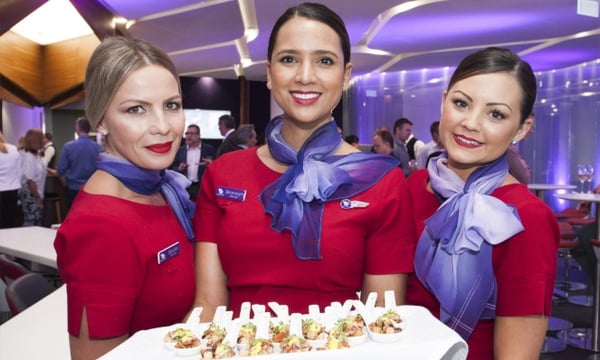 Three members of the Virgin Australia cabin crew serving canapés.